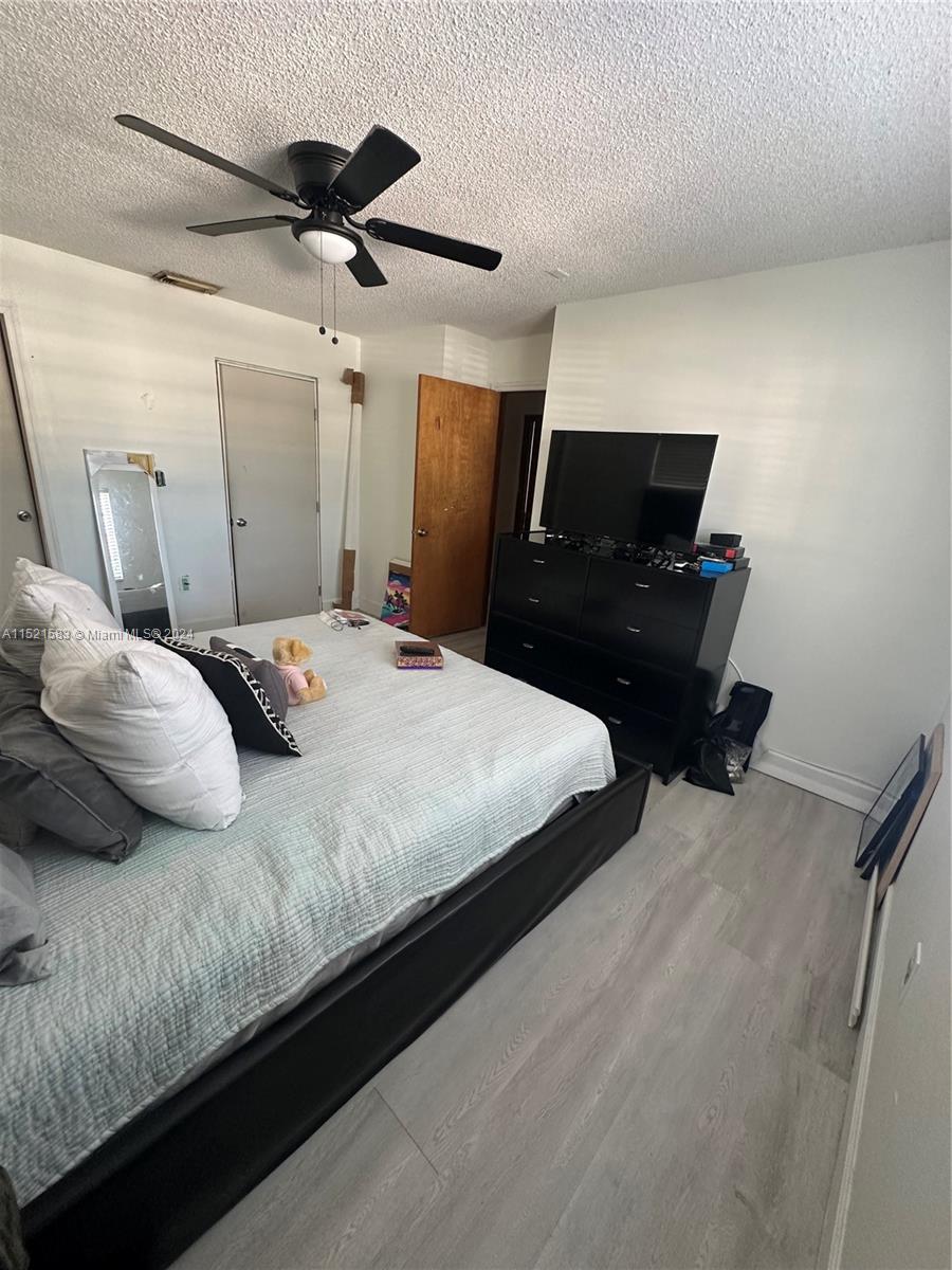 3196 West 79th Place Hialeah, FL 33018 - Photo 8 of 19 a bedroom with a bed and a ceiling fan