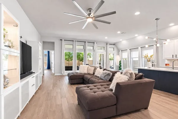 a living room with furniture tv and wooden floor