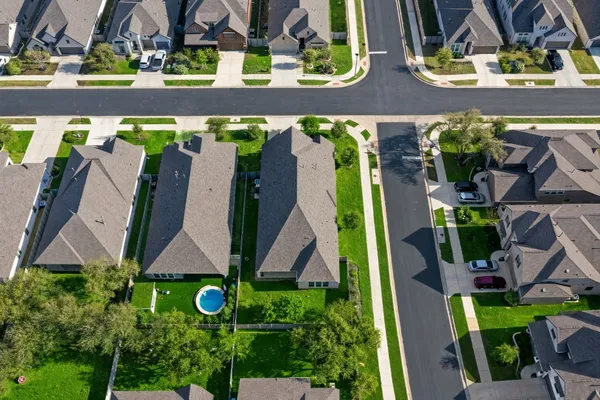 an aerial view of residential houses with outdoor space and river