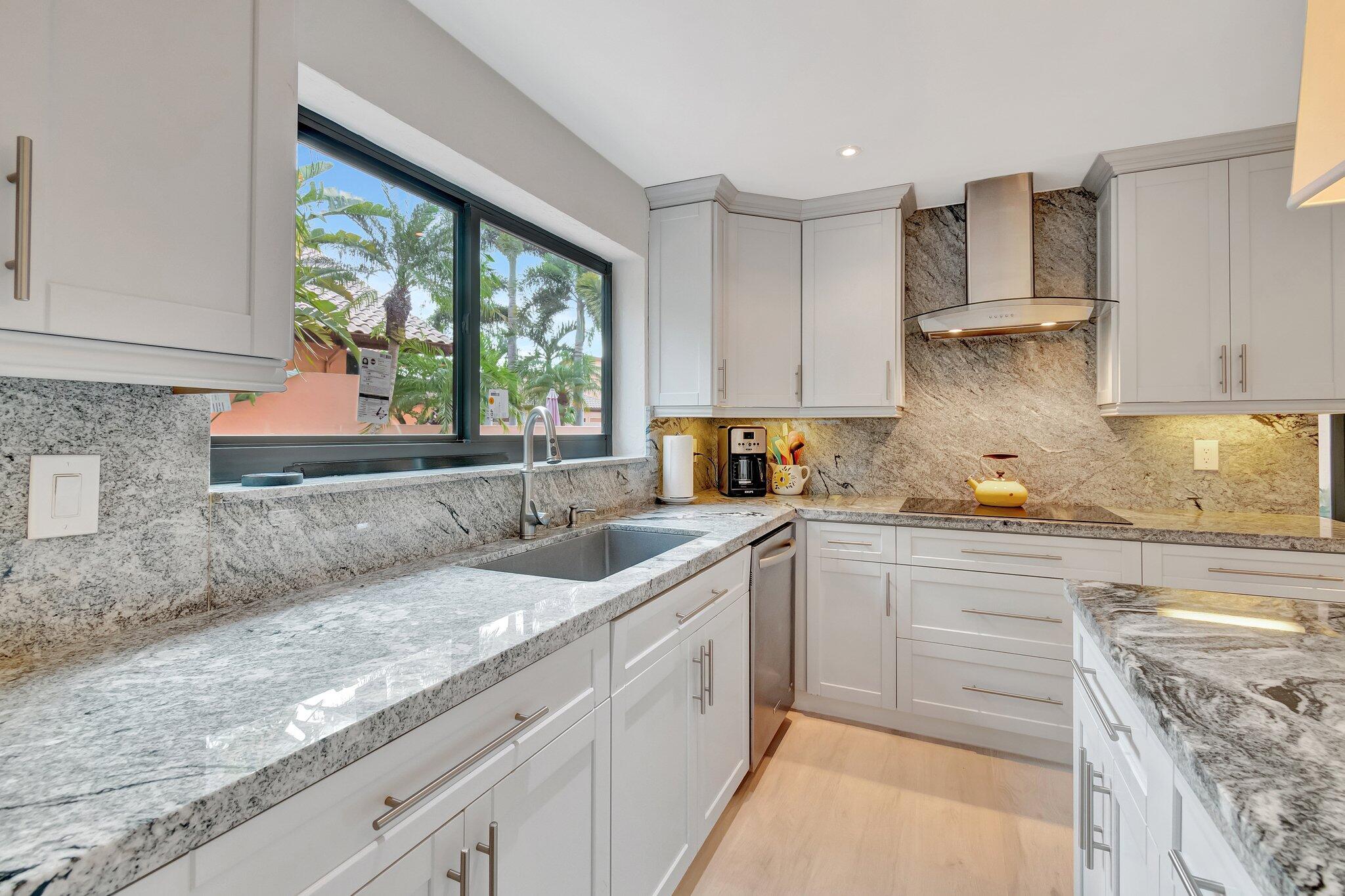 6427 Via Rosa Boca Raton, FL 33433 - Photo 11 of 80 a kitchen with a sink window and cabinets