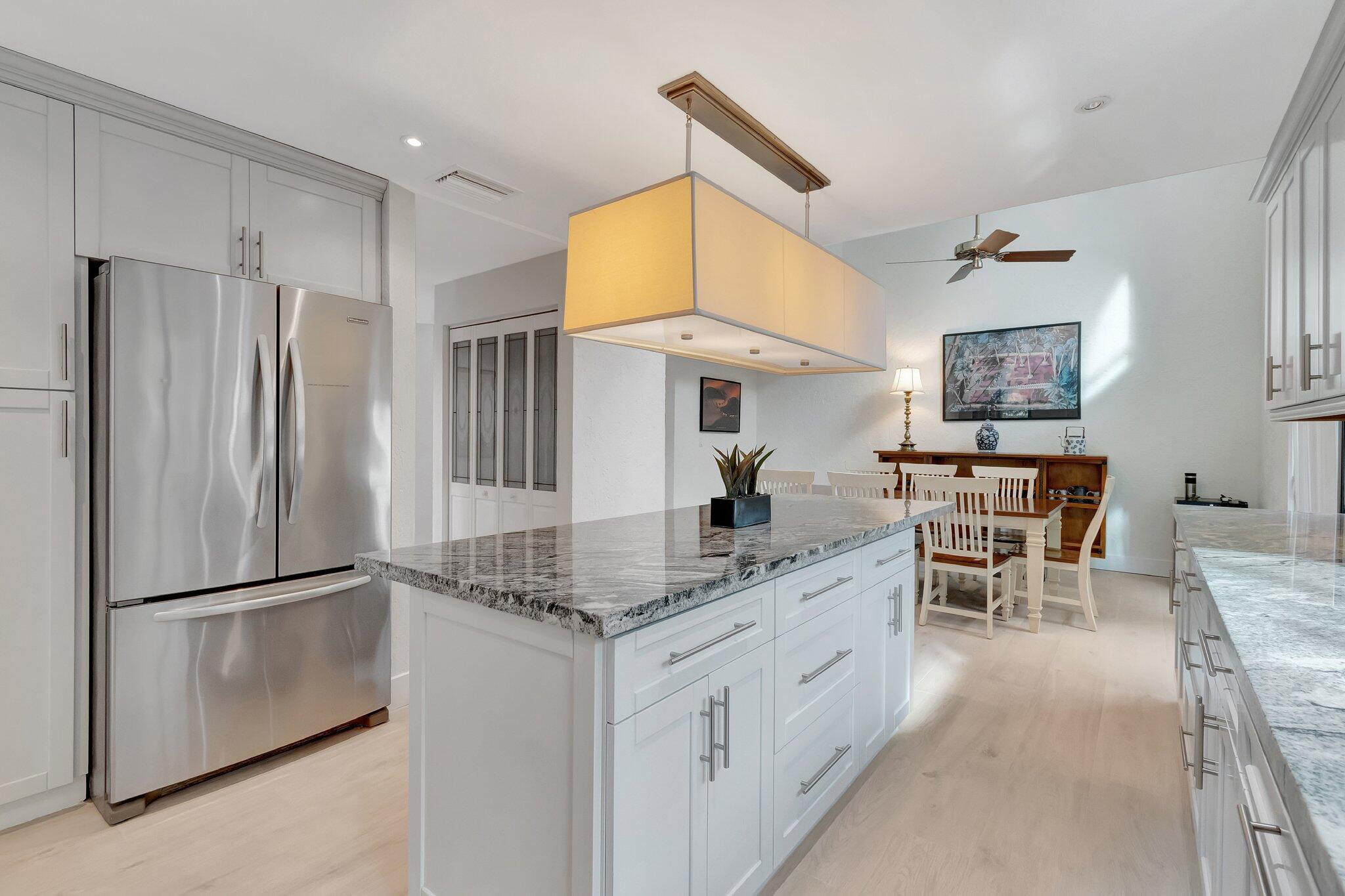 6427 Via Rosa Boca Raton, FL 33433 - Photo 16 of 80 a kitchen with stainless steel appliances granite countertop a refrigerator and a stove top oven