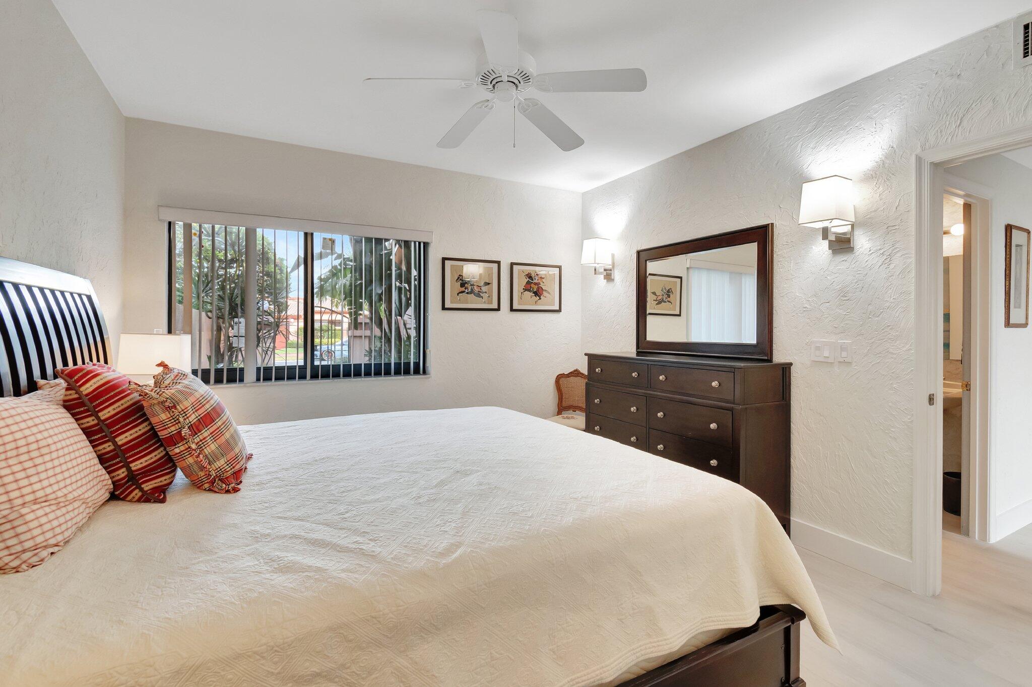 6427 Via Rosa Boca Raton, FL 33433 - Photo 38 of 80 a bedroom with a large bed and a tv