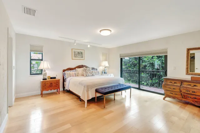 a view of a patio with table and chairs potted plants and floor to ceiling window and potted plants