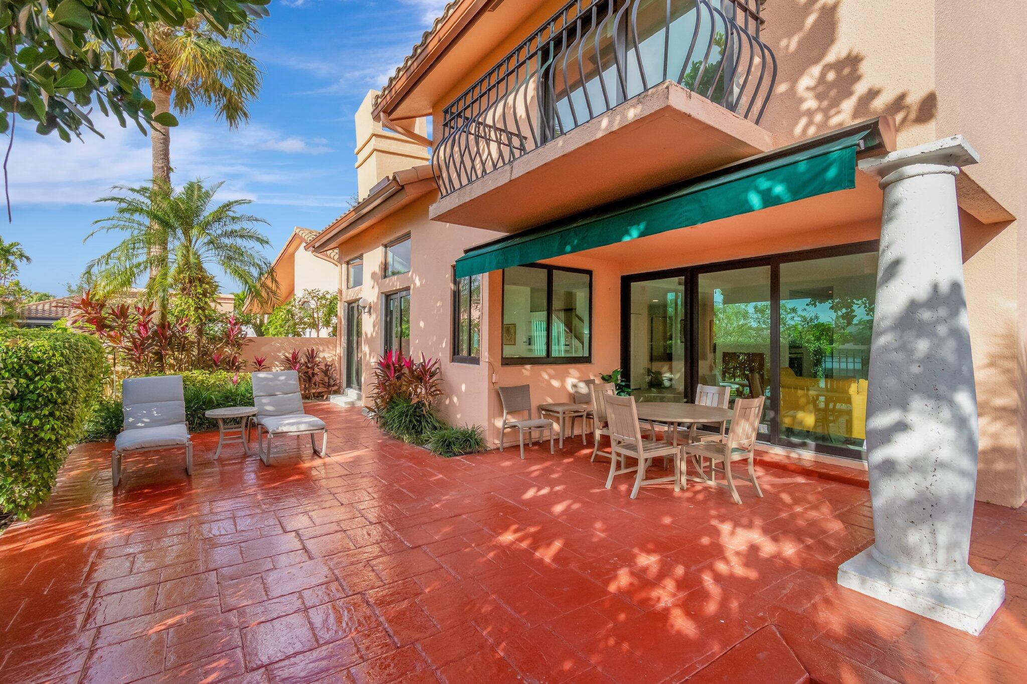 6427 Via Rosa Boca Raton, FL 33433 - Photo 64 of 80 a view of a patio with table and chairs under an umbrella