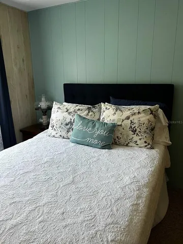 a bed sitting in a bedroom next to a wooden cabinet