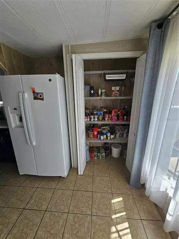 a view of storage and utility room with a refrigerator