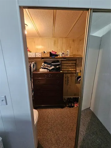 a room with water heater and wooden cabinets