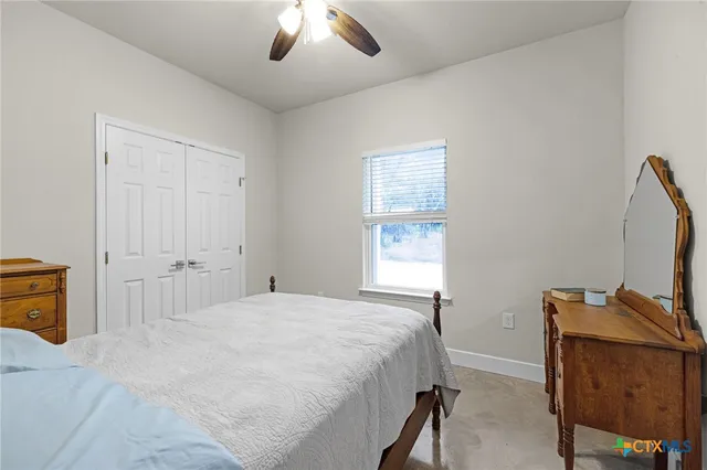 a bedroom with a bed and a flat tv screen on dresser