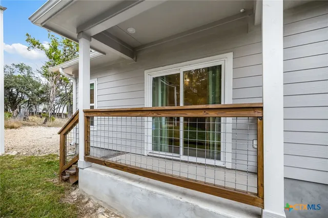 a view of a house with a large window and wooden fence