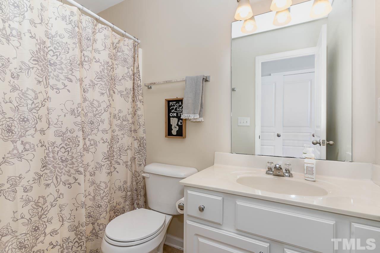 7859 Silverthread Lane Raleigh, NC 27617 - Photo 21 of 25 a bathroom with a sink a toilet and a mirror