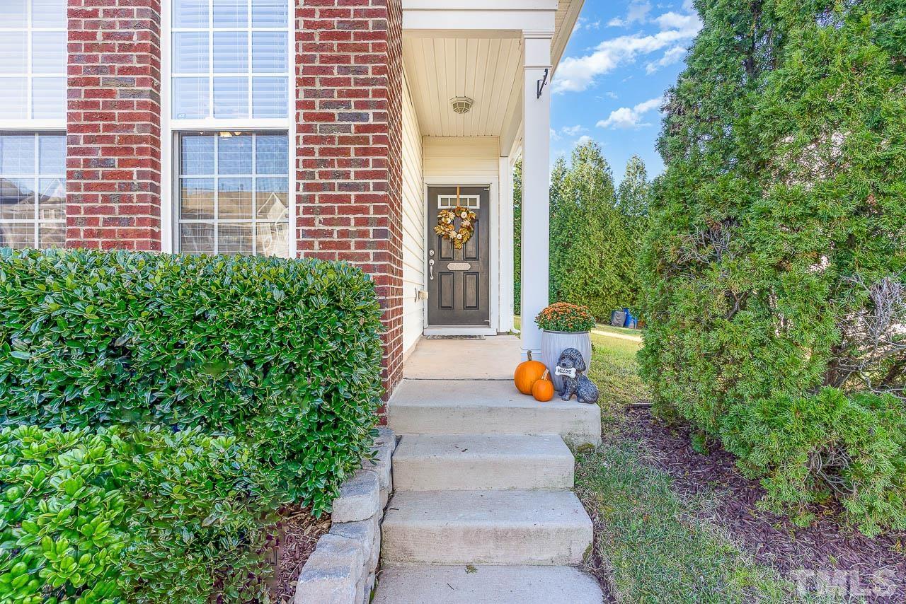7859 Silverthread Lane Raleigh, NC 27617 - Photo 3 of 25 a view of a house with potted plants and a fountain