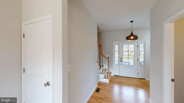 a view of a hallway with wooden floor and a living room