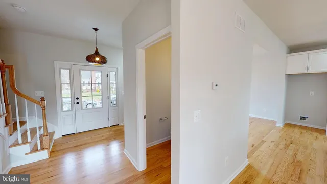 a view of hallway with wooden floor and stairs
