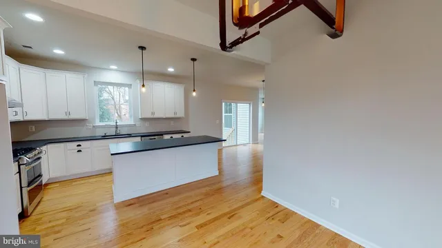 a large kitchen with kitchen island a sink stainless steel appliances and cabinets