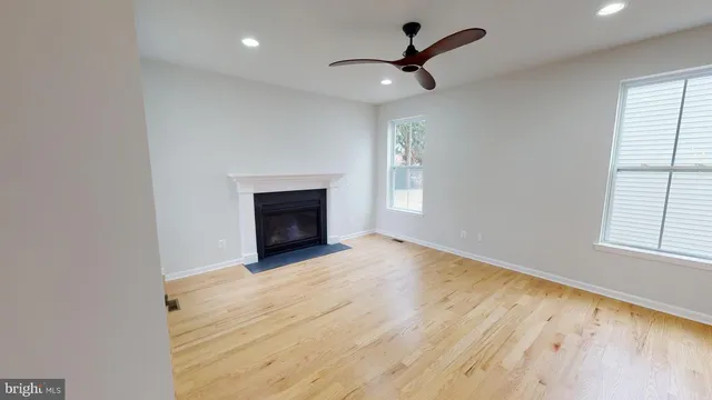 an empty room with windows and fireplace
