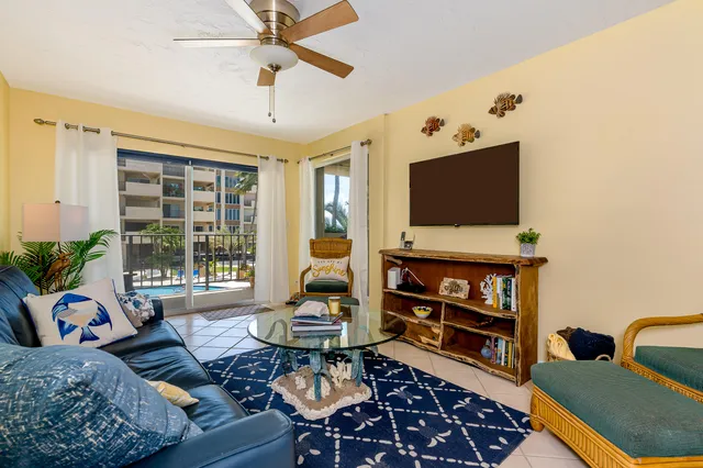 a large white kitchen with stainless steel appliances granite countertop a stove a sink a refrigerator and white cabinets with wooden floor