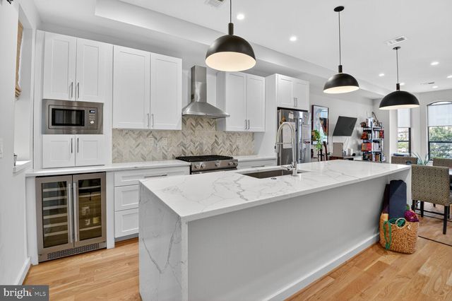 a kitchen with stainless steel appliances kitchen island sink stove and cabinets