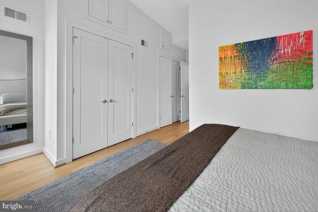 a bedroom with a bed and painting on the wall