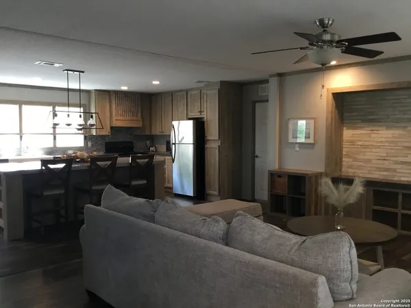a living room with furniture kitchen view and a refrigerator