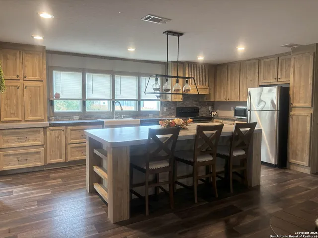 a kitchen with a table chairs refrigerator and microwave