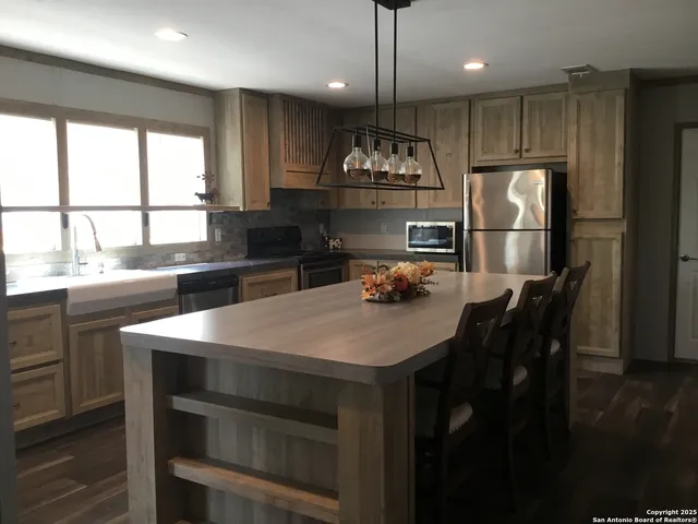 a kitchen with a table chairs refrigerator and microwave