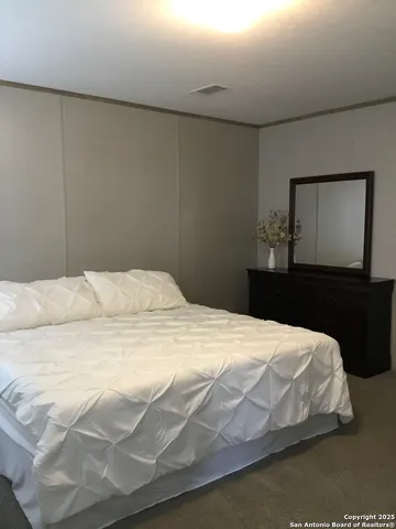 a bedroom with a bed and a mirror