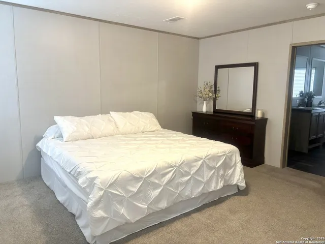 a large bed sitting in a bedroom next to a lamp