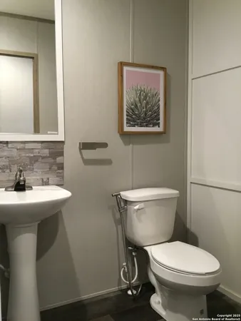 a bathroom with a toilet a sink and mirror