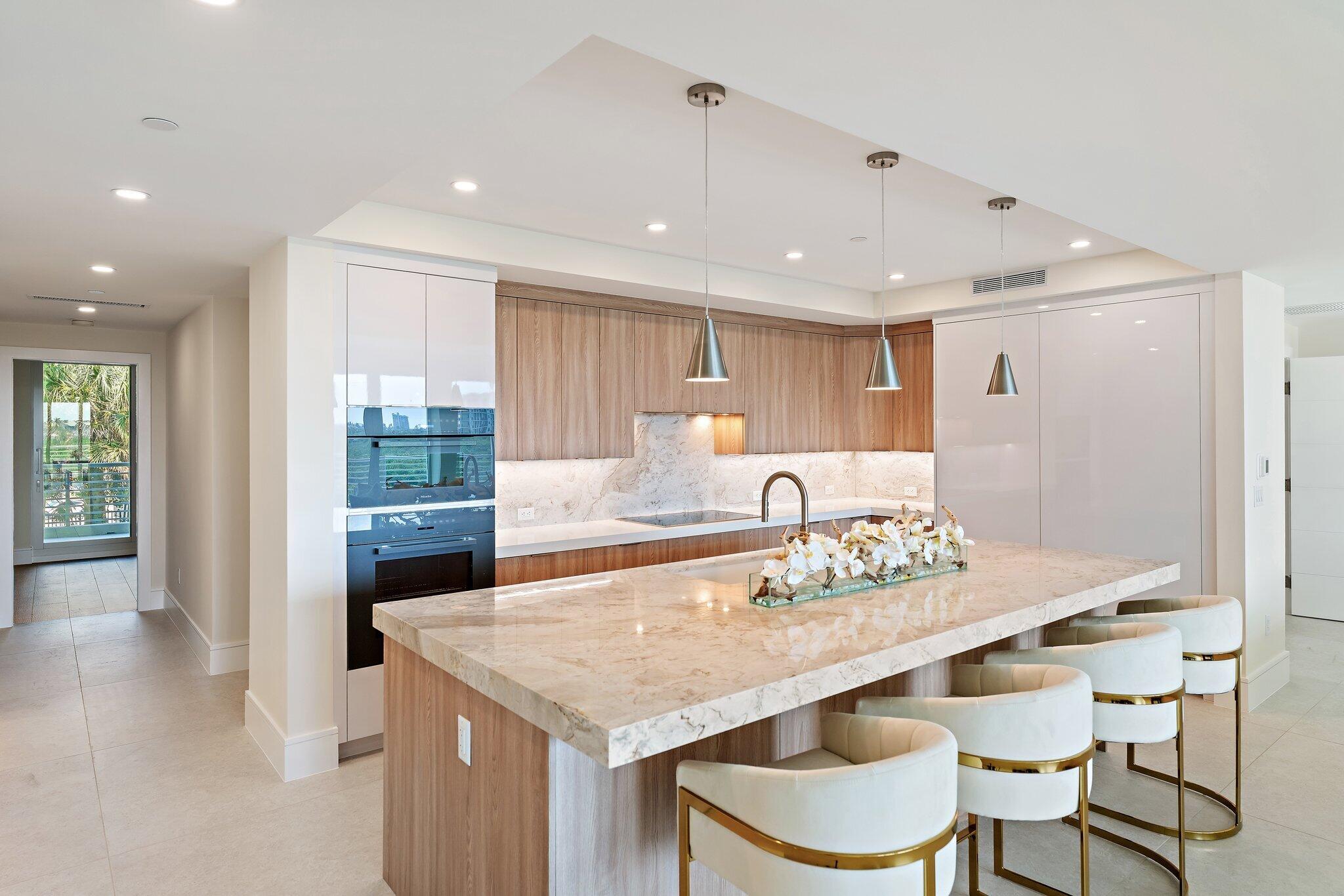 1 South Coastal Way, Unit 3030 Jupiter, FL 33477 - Photo 7 of 61 a dining hall with stainless steel appliances granite countertop a kitchen island a stove a table and chairs