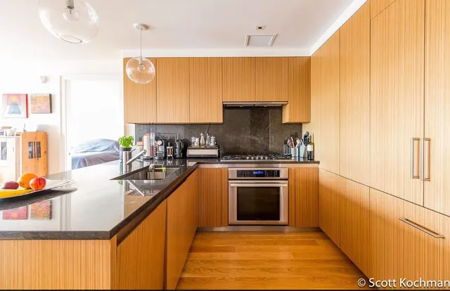 a kitchen with stainless steel appliances granite countertop a sink a stove and a refrigerator