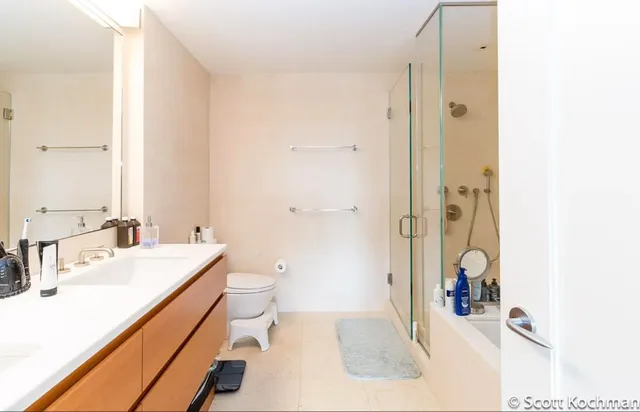 a bathroom with a sink a toilet and shower