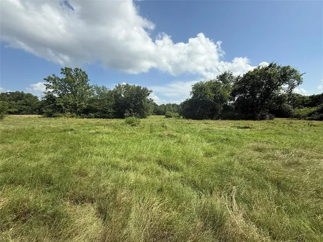 a view of a green field with wooden fence