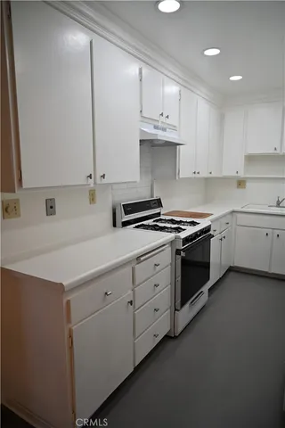 a kitchen with stainless steel appliances white cabinets and a sink