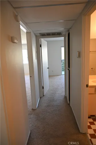 a view of hallway with closet and wooden floor