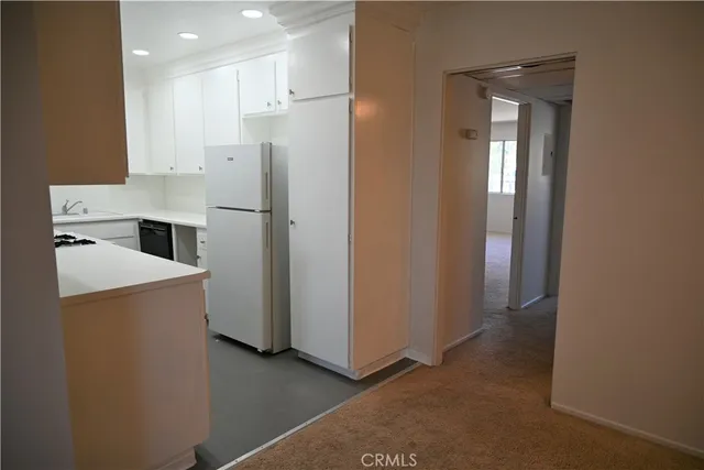 a kitchen with a refrigerator sink and cabinets