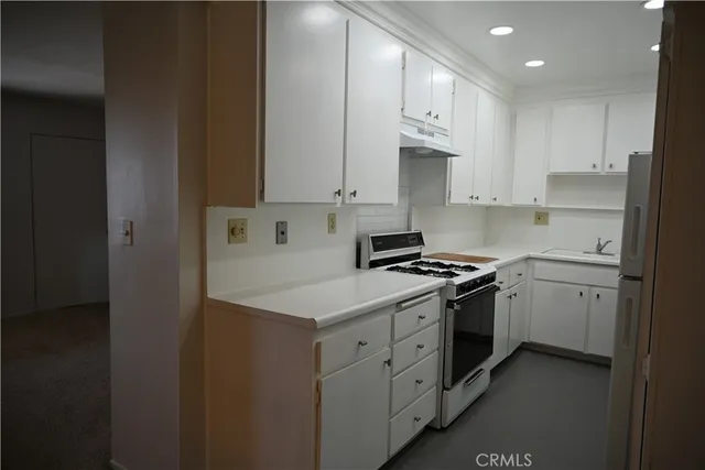 a kitchen with stainless steel appliances granite countertop a stove a sink and a refrigerator
