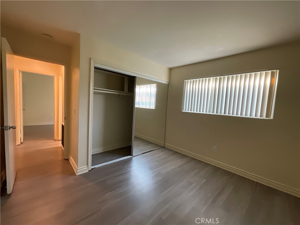 6042 Lime Avenue, Unit B Cypress, CA 90630 - Photo 13 of 20 an empty room with wooden floor cabinet and windows