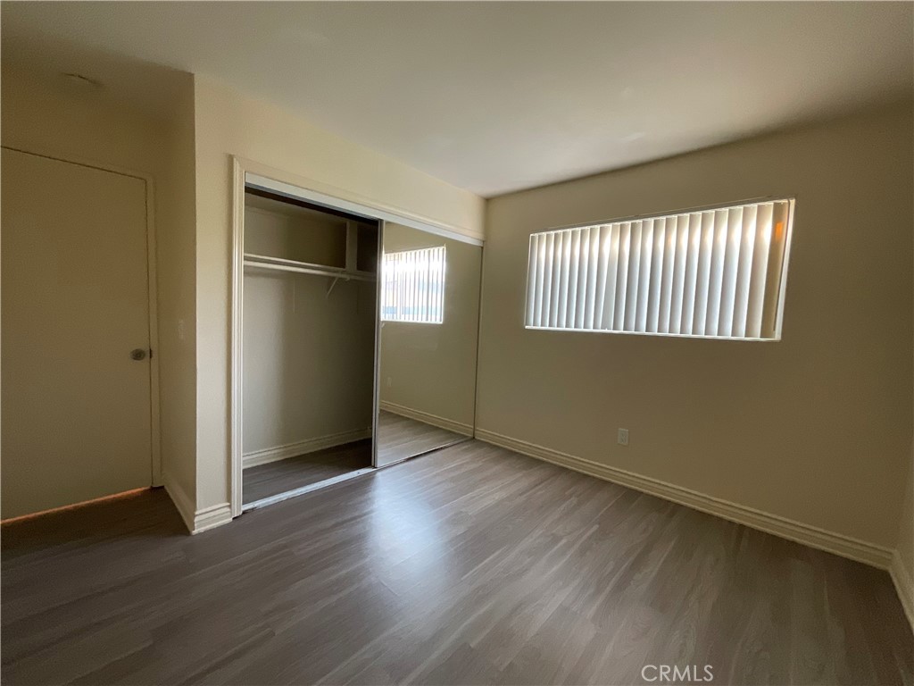 6042 Lime Avenue, Unit B Cypress, CA 90630 - Photo 14 of 20 an empty room with wooden floor cabinet and windows