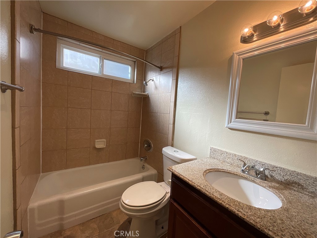 6042 Lime Avenue, Unit B Cypress, CA 90630 - Photo 16 of 20 a bathroom with a granite countertop sink toilet mirror and bathtub