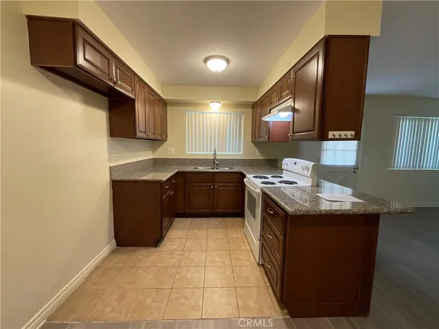 a kitchen with a stove sink and cabinets
