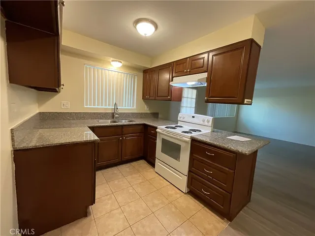 a kitchen with a stove sink and cabinets