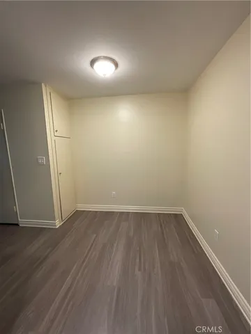 an empty room with wooden floor and white walls