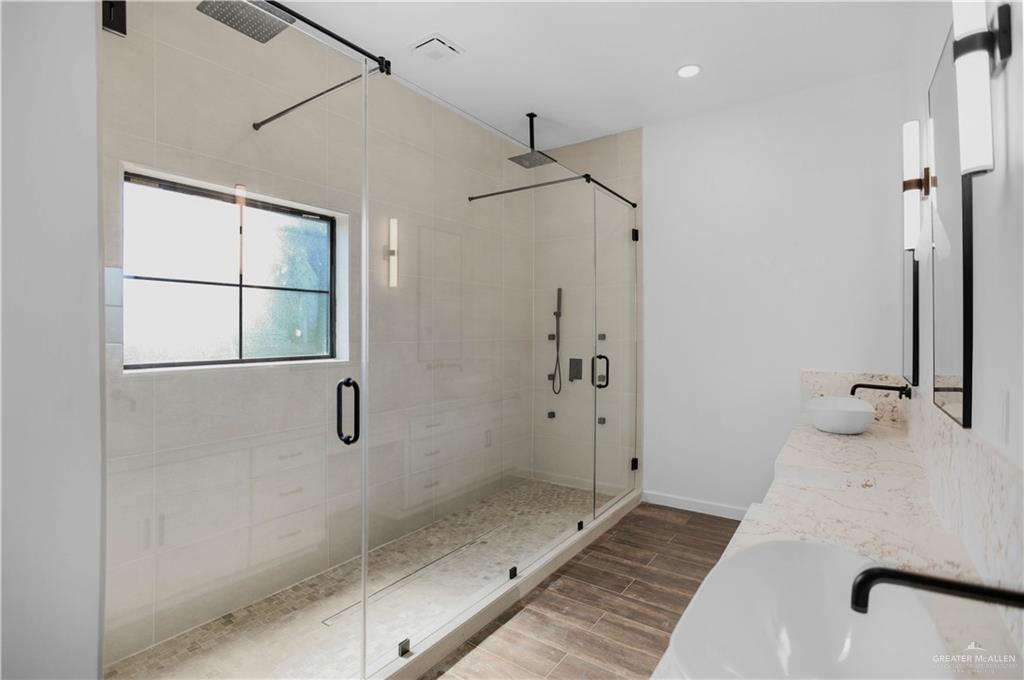 3730 East Davis Road Edinburg, TX 78542 - Photo 13 of 23 Full bathroom with a stall shower, wood finished floors, double vanity, and baseboards
