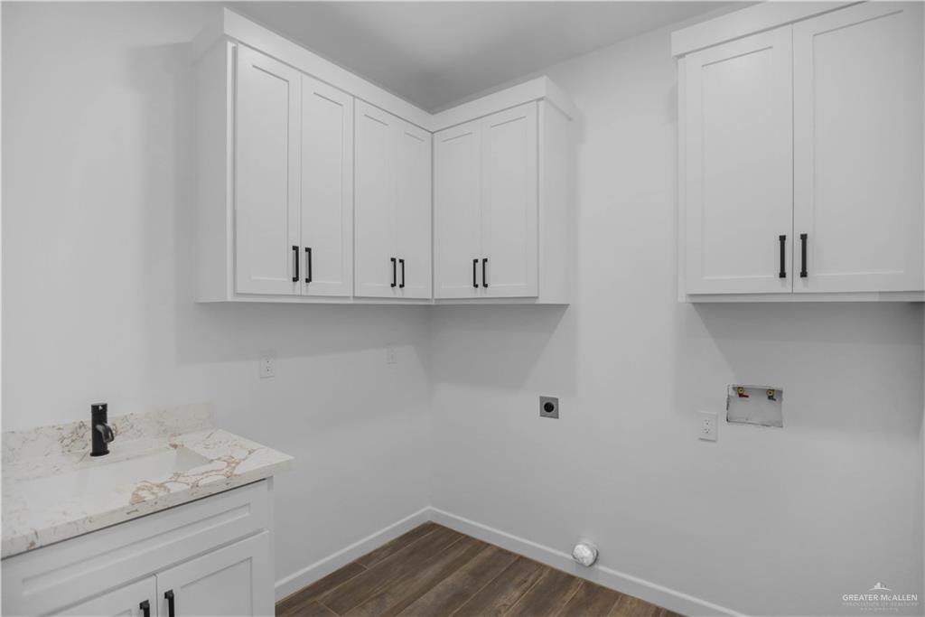 3730 East Davis Road Edinburg, TX 78542 - Photo 20 of 23 Washroom with hookup for a washing machine, hookup for an electric dryer, cabinet space, baseboards, and dark wood-style floors
