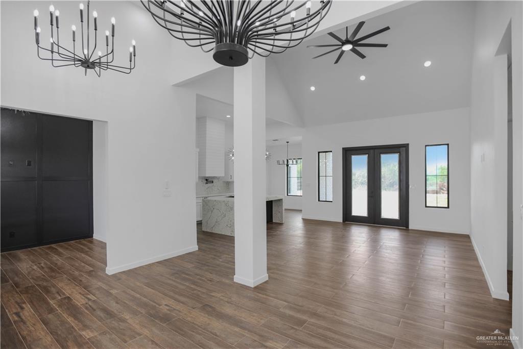 3730 East Davis Road Edinburg, TX 78542 - Photo 9 of 23 Entryway with high vaulted ceiling, baseboards, a chandelier, wood finished floors, and recessed lighting