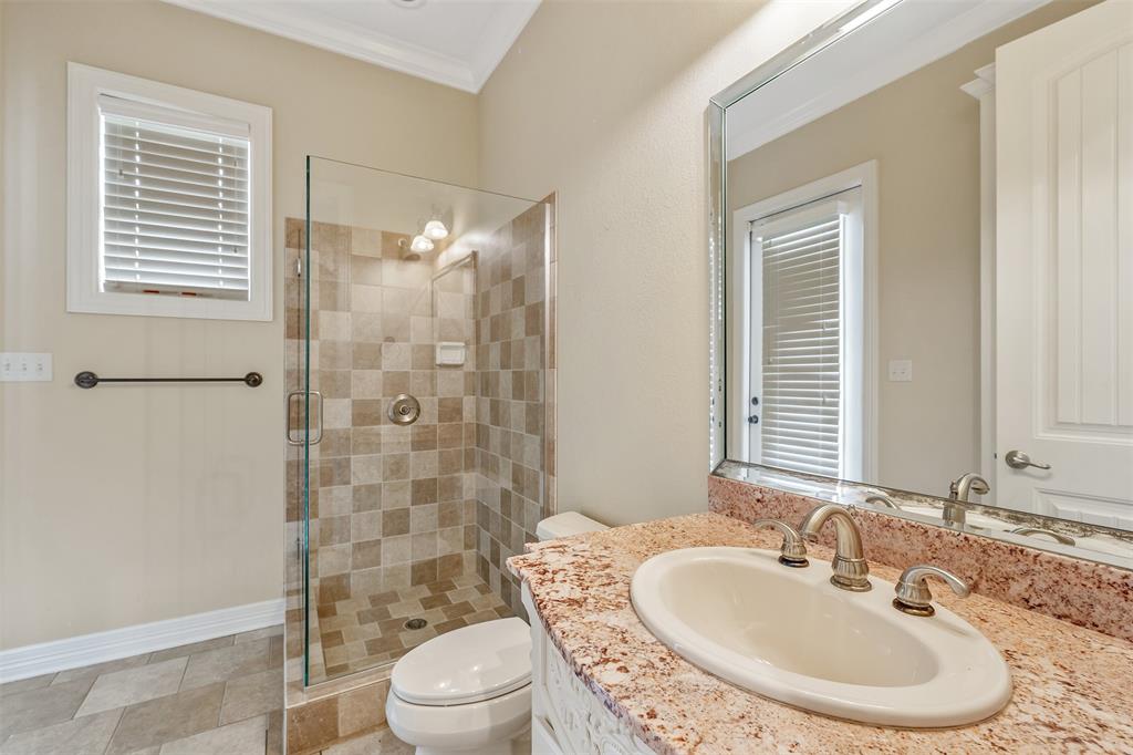 20389 County Road 178 Flint, TX 75762 - Photo 23 of 40 Bathroom featuring a glass-enclosed shower with tiled walls and flooring, a single vanity with a stone countertop, an oval undermount sink, and a framed wall mirror