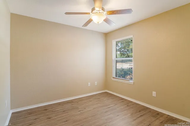 an empty room with a window and wooden floor
