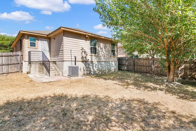 a backyard of a house with barbeque oven and covered with trees