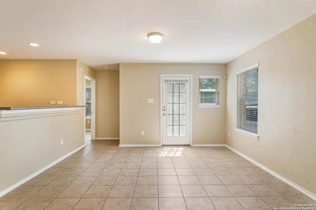 a view of an empty room with window and cabinet