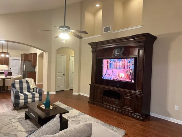 a living room with furniture a flat screen tv and a fireplace